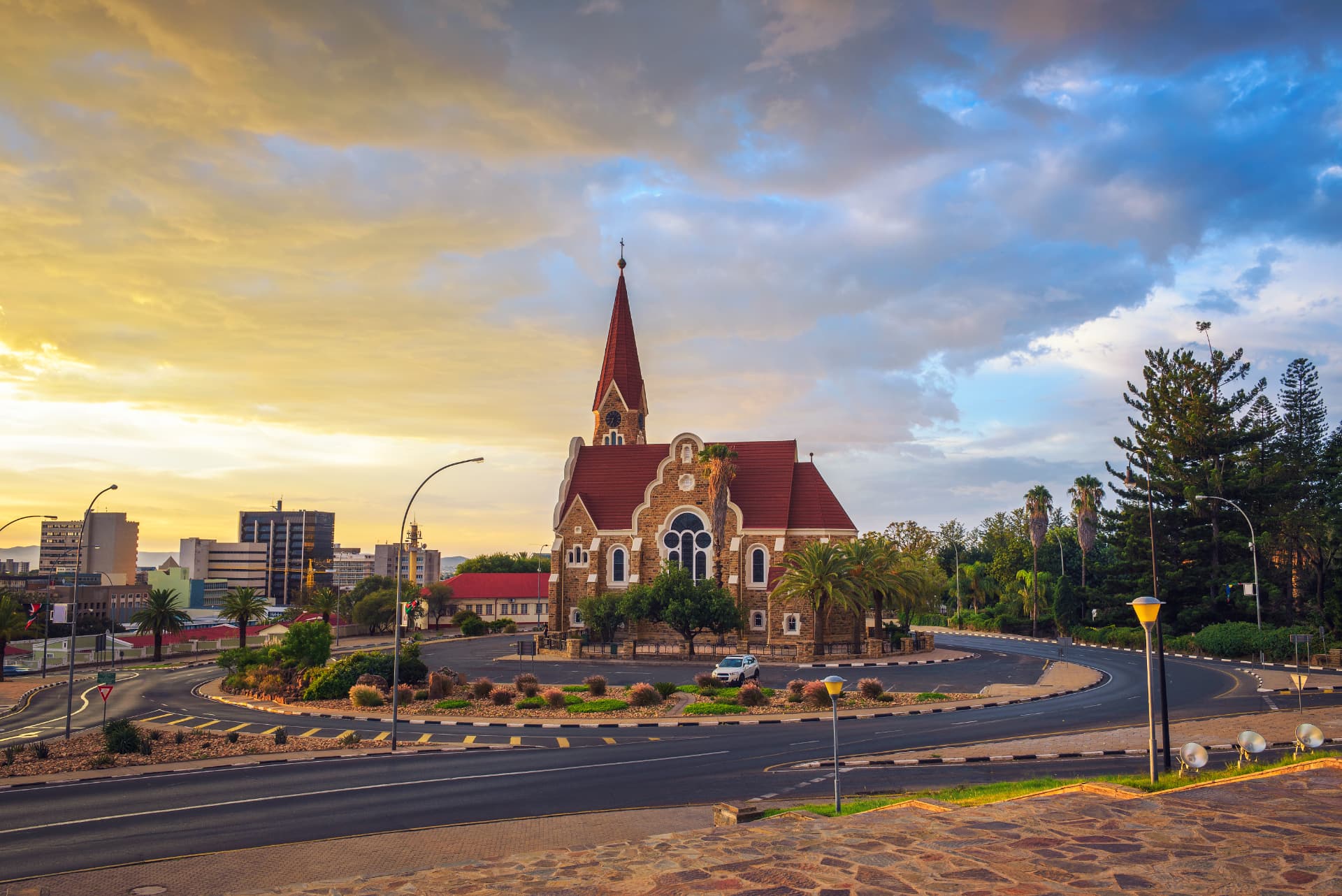 Christuskirche church in Windhoek at sunset with golden clouds and the city skyline behind