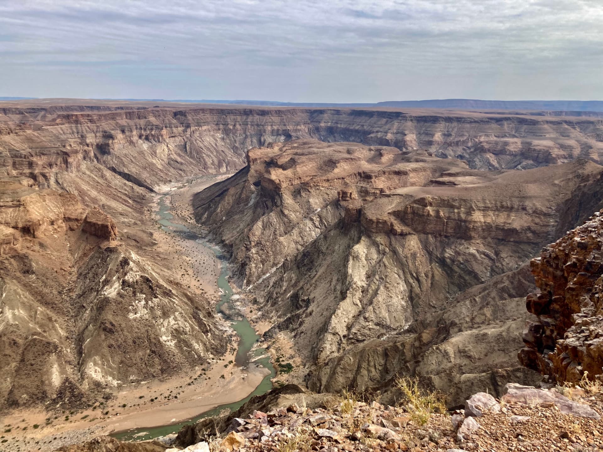 The Fish River winding in a deep green ribbon through the layered rock walls of Fish River Canyon